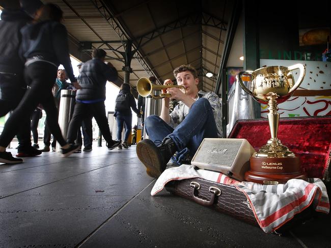 Busker Felix Meredith, of Malvern East, finds the most unusual tip he has ever had in his trumpet case at Flinders Street Station. Picture: David Caird