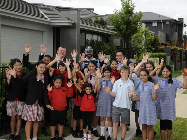 Campbelltown councillor Darcy Lound, Constable Rob MacFarlane and Minto Marketplace centre manager Michael Prestia join with Sarah Redfern and Minto Primary Students to launch Minto on the Go in 2014. Picture: Tim Clapin