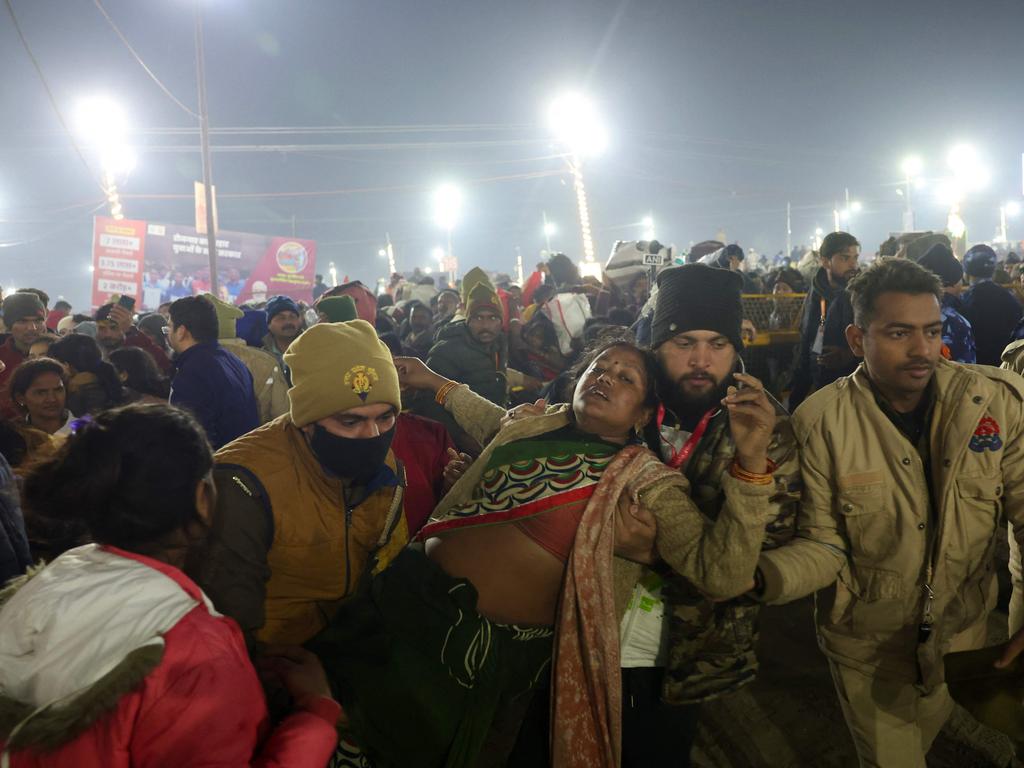 Police personnel carry a lady as she fainted at the site of stampede. Picture: AFP