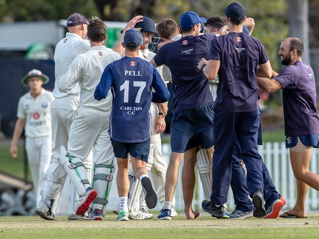 Jubilant Carlton players gather on the pitch after Evan Gulbis brings up the winning runs with a boundary.<br/>                     