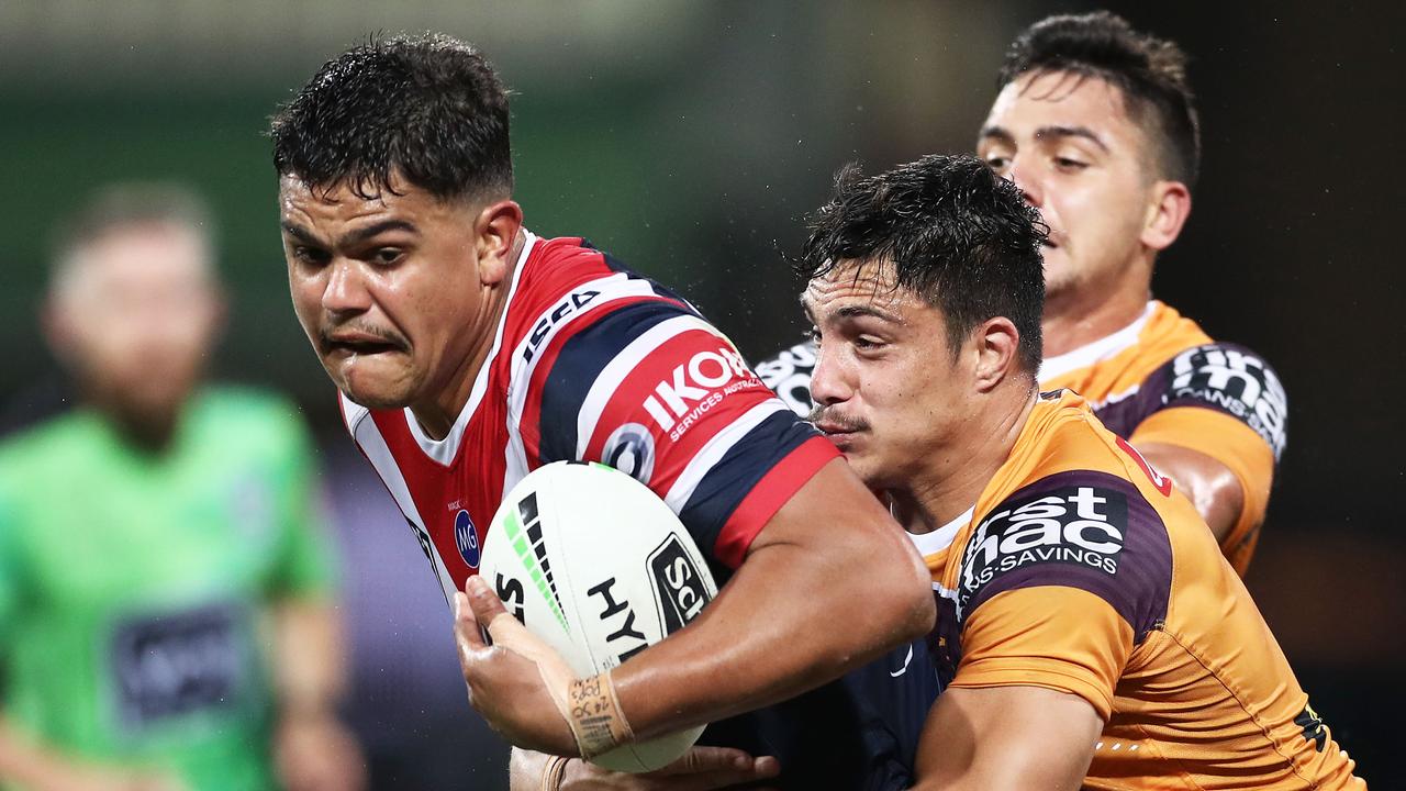Latrell Mitchell of the Roosters is tackled by the Broncos defence
