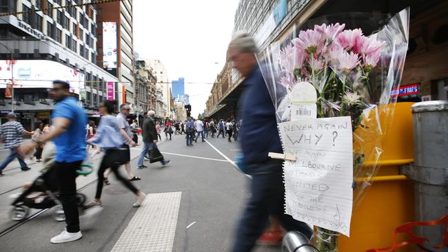 A note and flowers placed at the scene where the SUV crashed into the tram barrier as pedestrians cross into Elizabeth St on Friday morning. Picture: David Caird