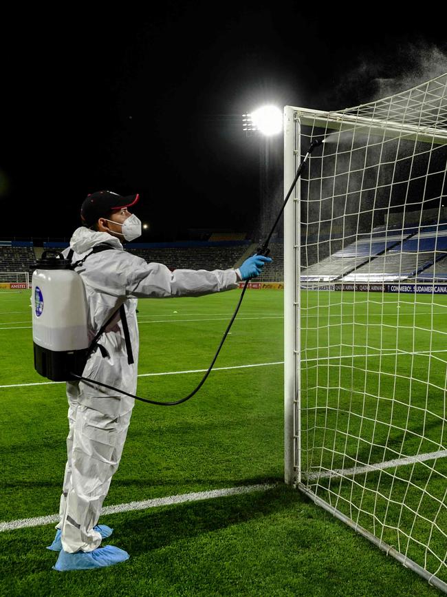 A worker disinfects the goal before a Copa Sudamericana football tournament all-Chilean first round match at the San Carlos de Apoquindo Stadium in Santiago. Picture: AFP