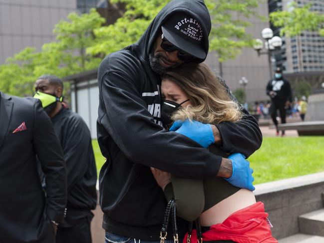 Former NBA player Stephen Jackson hugs a woman after speaking at a protest.