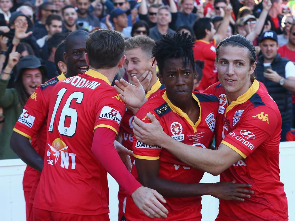 Bruce Kamau (centre) celebrates with his then Adelaide United teammates after scoring in the 2016 A-League grand final. Picture: Robert Cianflone/Getty Images