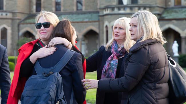 Parent Sam Baker hugs her daughter, a student at PCW. They are pictured with principal Filina Virgato (second from right) and school parent Janet Mitchell. Picture: Sarah Matray