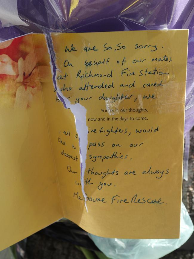 A card from firefighters at a flower memorial at the site where a cyclist was killed on Chapel St. Picture: David Crosling