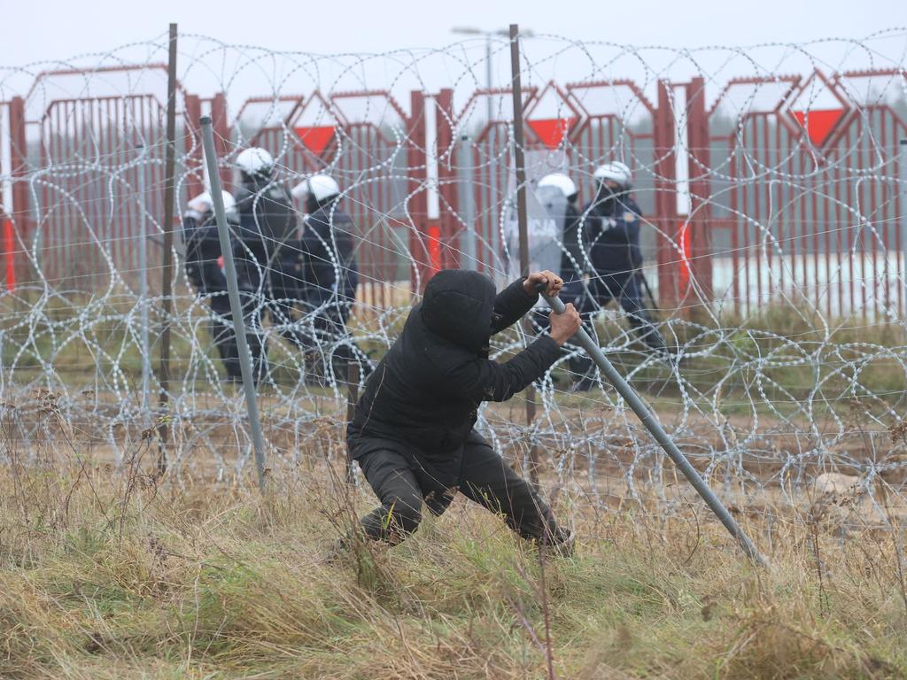 Ein Mann versucht, den Zaun zu zerstören.  Bild: Leonid Shcheglov/Belta/AFP