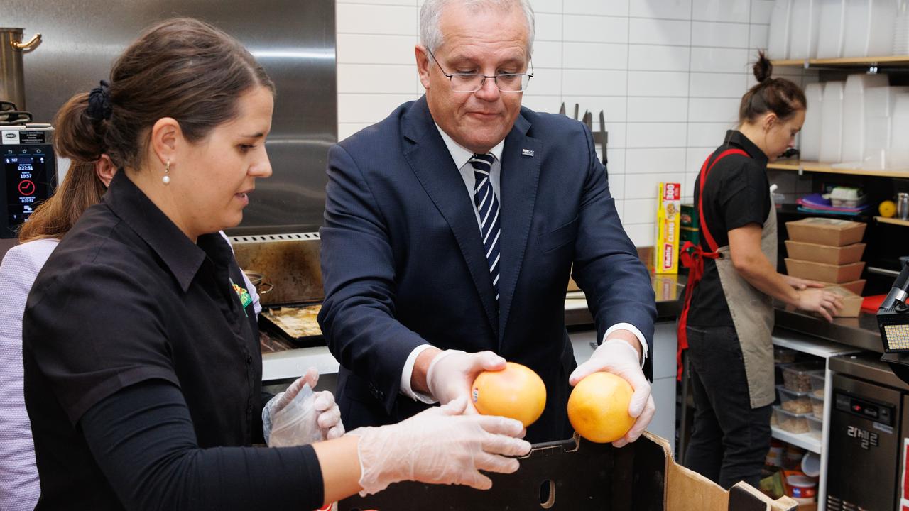 The Prime Minister tries his hand at packing fruit while visiting Palamara Village Fruits, Mount Eliza. Picture: Jason Edwards