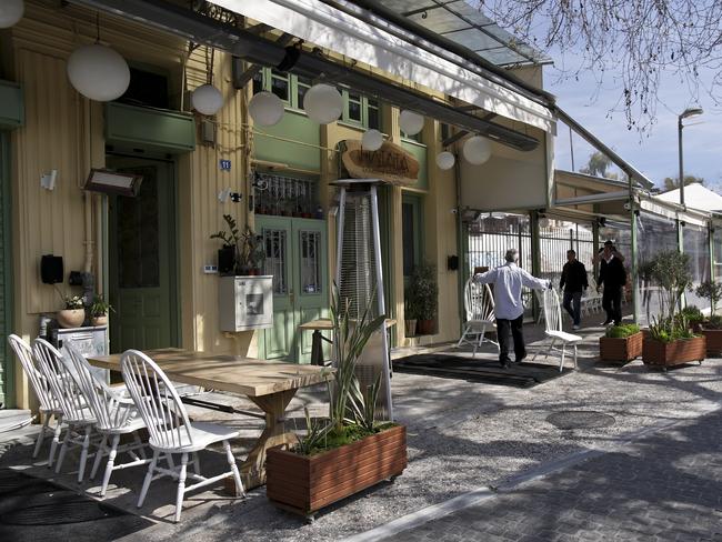 Workers collect seats outside a closed cafe-restaurant in Athens, Greece. Picture: Getty