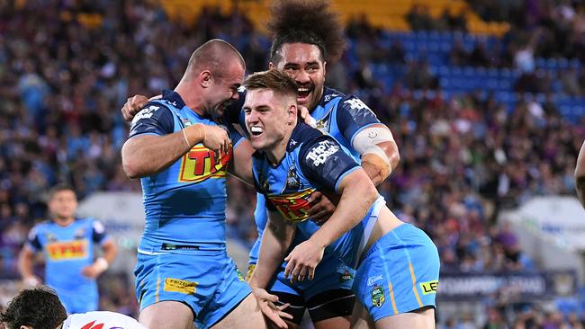 A J Brimson of the Titans (centre) reacts after scoring a try ahead of Billy Slater of the Storm during the Round 24 NRL match between the Gold Coast Titans and the Melbourne Storm at Cbus Super Stadium on the Gold Coast, Saturday, August 25, 2018. (AAP Image/Dave Hunt) NO ARCHIVING, EDITORIAL USE ONLY