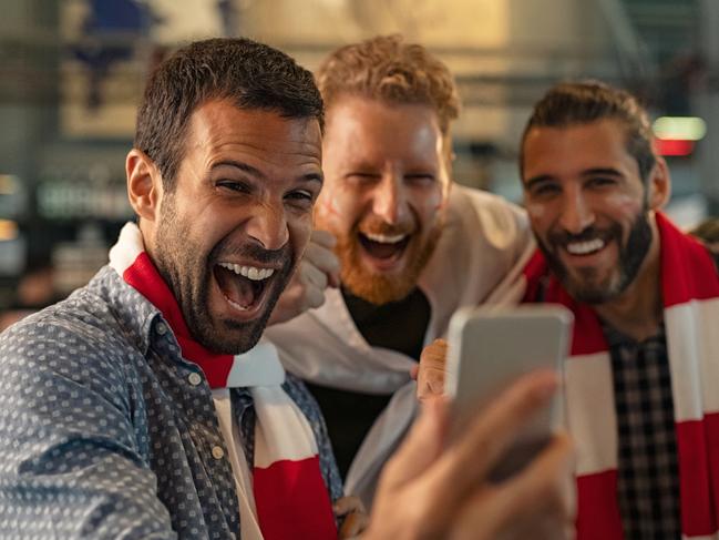 Excited men watching football in streaming on smartphone winning an online bet; generic gambling betting