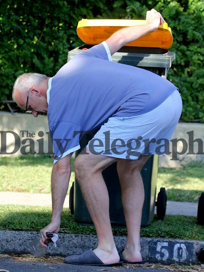 Mr Foley stoops to pick up rubbish outside his home. Picture: John Grainger