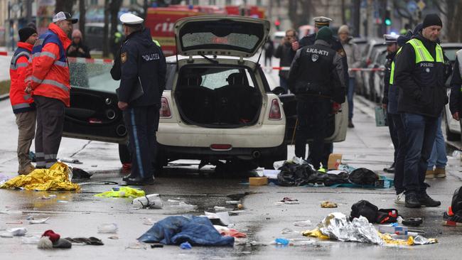 Police and emergency services personnel near a damaged car that drove into demonstrators marching in Munich on Tuesday. Picture: Getty Images