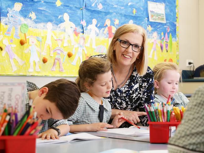 Teacher Monique Dickson poses with students Braxton Jarvis, 6, Penny Waterhouse, 6, and Annabelle Pitt, 6, from class 1G at St MartinÕs Catholic Primary School in Carina, Brisbane on Friday, September 21, 2018. The Catholic schools system in Queensland is the first non-government education authority to roll out phonics screening for Year 1 students. Photo: Claudia Baxter