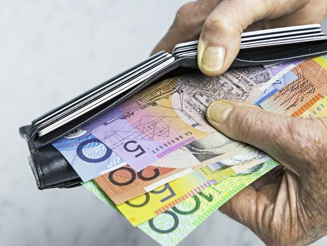 Payment. Close-up, senior female hands taking Australian banknotes (cash, currency) from purse containing many credit cards.  Horizontal, studio, copy space, spread notes.