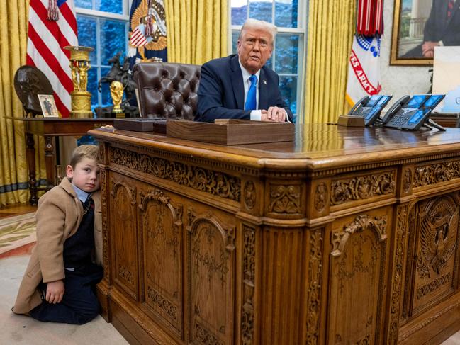 X leans on the Resolute desk as US President Donald Trump looks on in the Oval Office. Picture: AFP