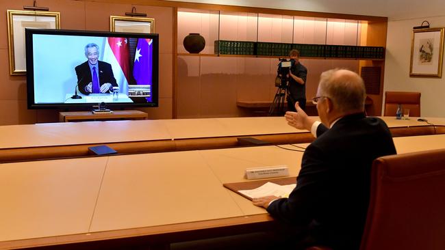 Scott Morrison signals a virtual handshake with Singapore's Prime Minister Lee Hsien Loong in March. Picture: AFP