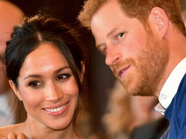 CARDIFF, WALES - JANUARY 18:  Prince Harry whispers to Meghan Markle as they watch a dance performance by Jukebox Collective in the banqueting hall during a visit to Cardiff Castle on January 18, 2018 in Cardiff, Wales. (Photo by Ben Birchall - WPA Pool / Getty Images)