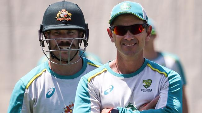 Warner and coach Justin Langer share a smile during a net session ahead of the SCG Test. Picture: David Gray/AFP