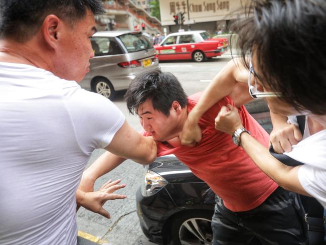 Pro Beijing supporters scuffle with a man at North Point in Hong Kong. Months of protests in Hong Kong have taken a major toll on the city's economy, with no end in sight. Picture: AFP