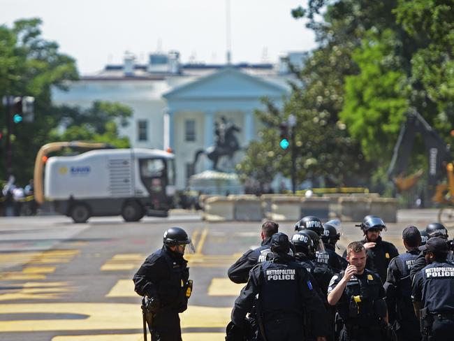 A group of police officers in riot gear are seen with the statue of former US president Andrew Jackson framed by the White House in the background. Picture: Brendan Smialowski