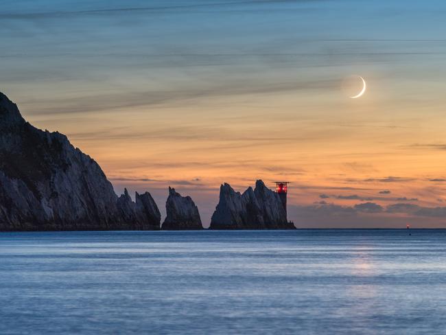 Insight Astronomy Photographer of the Year 2017 shortlist selection: Crescent Moon over the Needles . Picture: Ainsley Bennett (UK) The 7% waxing crescent Moon setting in the evening sky over the Needles Lighthouse at the western tip of the Isle of Wight. Despite the Moon being a thin crescent, the rest of its shape is defined by sunlight reflecting back from the Earth’s surface. Alum Bay, Freshwater, Isle of Wight, UK, 3 October 2016