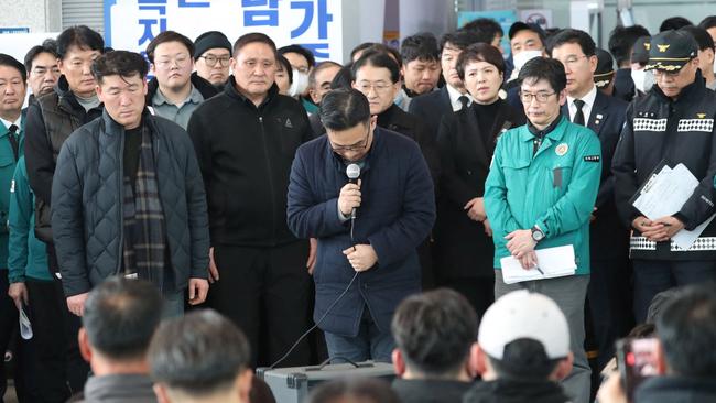 A Jeju Air official (C) bows his head and apologises to the bereaved families of passengers of the Jeju Air passenger plane that crashed and burst into flames at Muan International Airport. Picture: AFP