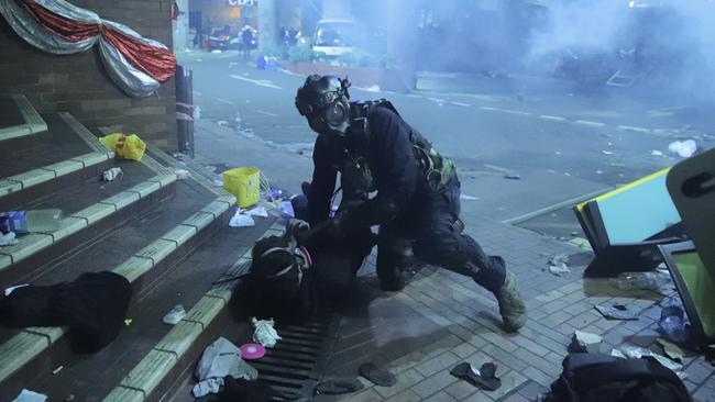 A policeman in riot gear detains a protester outside of Hong Kong Polytechnic University on Monday. Picture: AP Photo/Kin Cheung