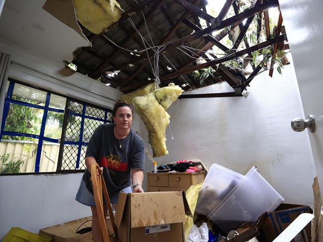 Lizzy Burke tries to clean up her Elanora home after a tree went through the roof. Picture: Adam Head