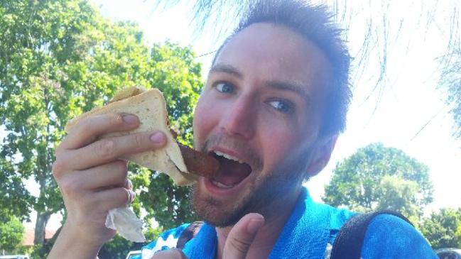 Gold Coast Bulletin reporter Jerad Williams trying a rare sausage at Albert Waterways Community Centre.