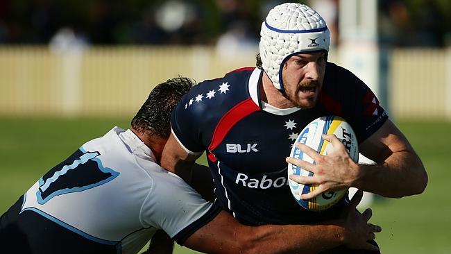 Rebels lock Hugh Pyle attempts to bust a tackle from a Waratah defender.