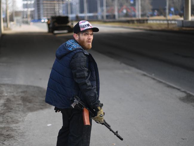 A volunteer, holding a rifle, protects a main road leading into Kyiv. Picture: AFP.