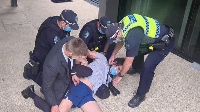 Police restrain the man on the ground. Picture: Andrew Hough