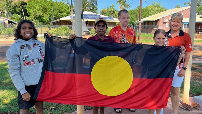 Jo Hersey presenting an Aboriginal Flag to Macfarlane Primary School, Katherine. Picture: Supplied