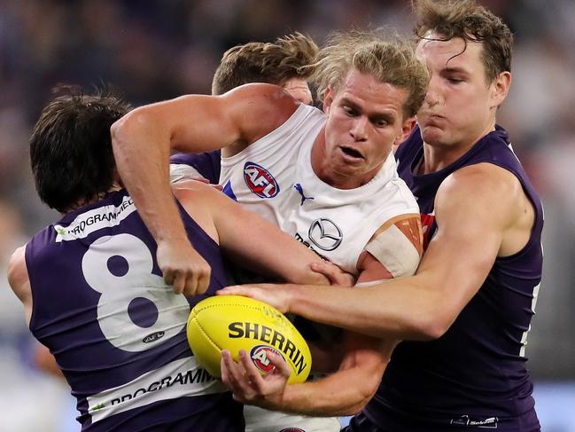 Jed Anderson of the Kangaroos is swamped by Dockers opponents. Picture: Will Russell/AFL Photos via Getty Images