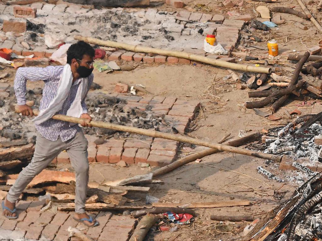 A man adjusts the funeral pyre at a cremation ground in New Delhi on May 2. Picture: Tauseef Mustafa/AFP