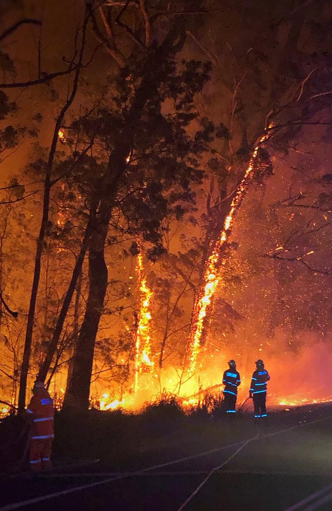 Firefighters work on the Currowan bushfire along the Princes Highway in Austinmer on Sunday. Picture: AAP