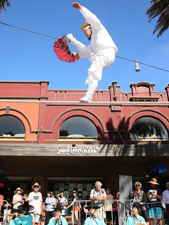 Master Kim walks the tight-rope above The Corso at Manly on Sydney's Northern Beaches. He was joined by a colourful display of Korean dancers & musicians who entertained a large crowed that gathered to see the spectacle. Picture: Troy Snook