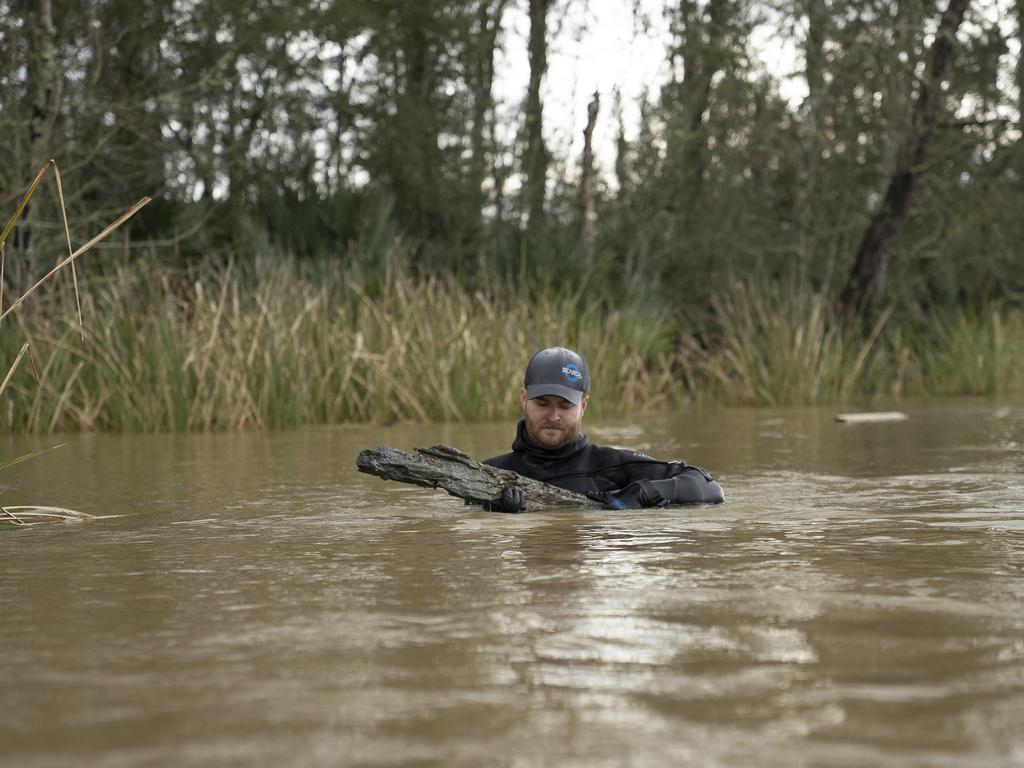 Maritime archaeologist Kyle Lent examines a wooden plank from the hull of Clotilda. Picture: AP