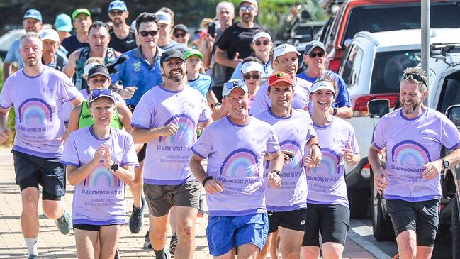 Asa Cowell, centre, finishes running his 50th marathon in 50 days at Seacliff raising money for Catherine House. Picture: Brenton Edwards