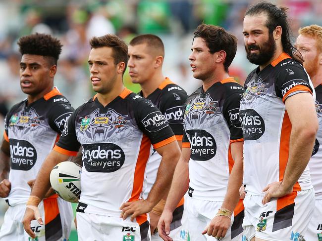 Tigers players watch on after a Raiders score another try.