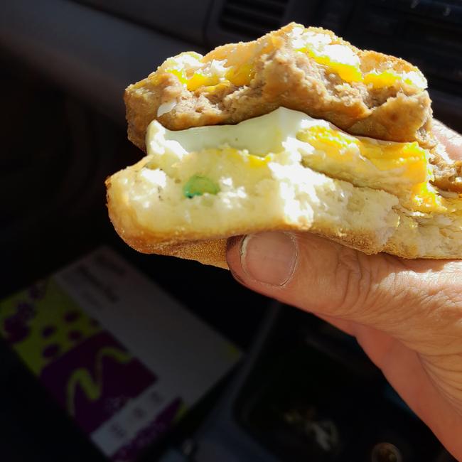 The sausage and egg McMuffin with part of the green plastic glove in it.