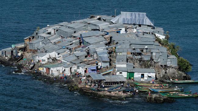 A picture taken on October 5, 2018, shows a general view of Migingo island which is densely populated by residents fishing mainly for Nile perch in Lake Victoria on the border of Uganda and Kenya. - A rounded rocky outcrop covered in metallic shacks, Migingo Island rises out of the waters of Lake Victoria like an iron-plated turtle. The densely-populated island is barely a quarter of a hectare large, its residents crammed into a hodge-podge of corrugated-iron homes, with seemingly little but a few bars, brothels and a tiny port to boast of. (Photo by Yasuyoshi CHIBA / AFP)