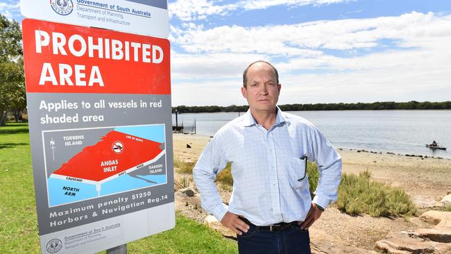 Kayaker Bob Newlands with a confusing speed limit sign at the Angus Inlet boat ramp on Garden Island. Picture: AAP/Keryn Stevens