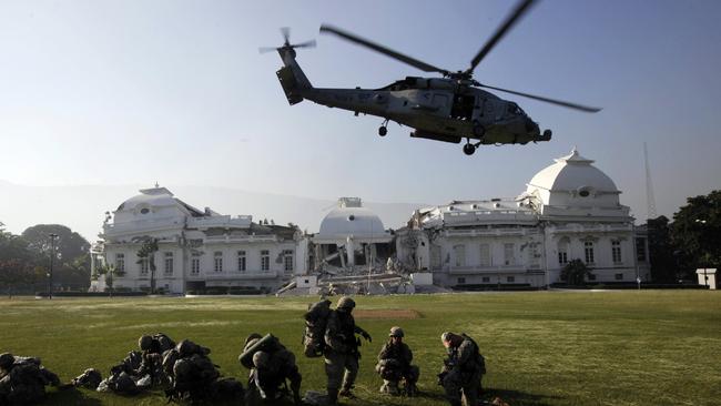 A US navy helicopter takes off in front of the stricken National Palace in Port-au-Prince following the devastating 2010 earthquake. (AP Photo/Gregory Bull)