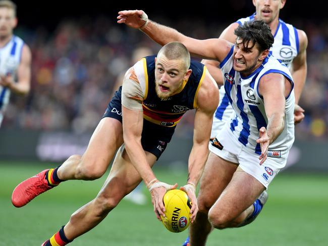 Hugh Greenwood of the Crows is tackled by Jarrad Waite of the Kangaroos.