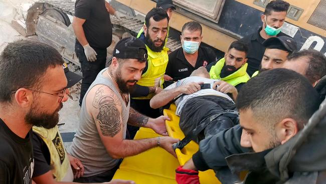 Rescuers transport a survivor from the site of an Israeli airstrike that targeted overnight the southern Lebanese city of Tyre on October 28, 2024, amid the ongoing war between Israel and Hezbollah. (Photo by Kawnat HAJU / AFP)