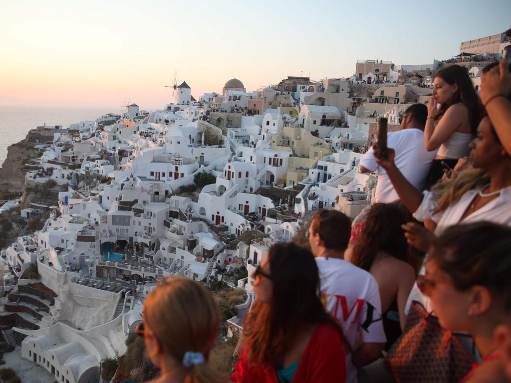 Tourists wait for the sunset in the village of Oia on the Greek island of Santorini on July 20, 2024. Picture: Aris Oikonomou / AFP