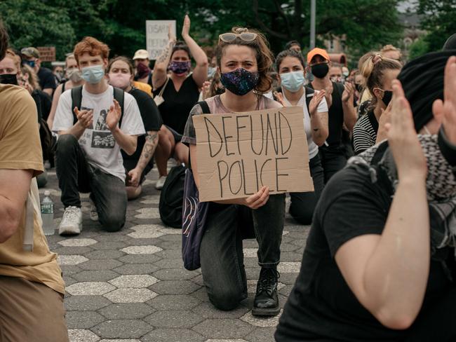 Demonstrators denouncing systemic racism in law enforcement and calling for the defunding of police departments kneel in Maria Hernandez Park in the borough of Brooklyn. Picture: Getty